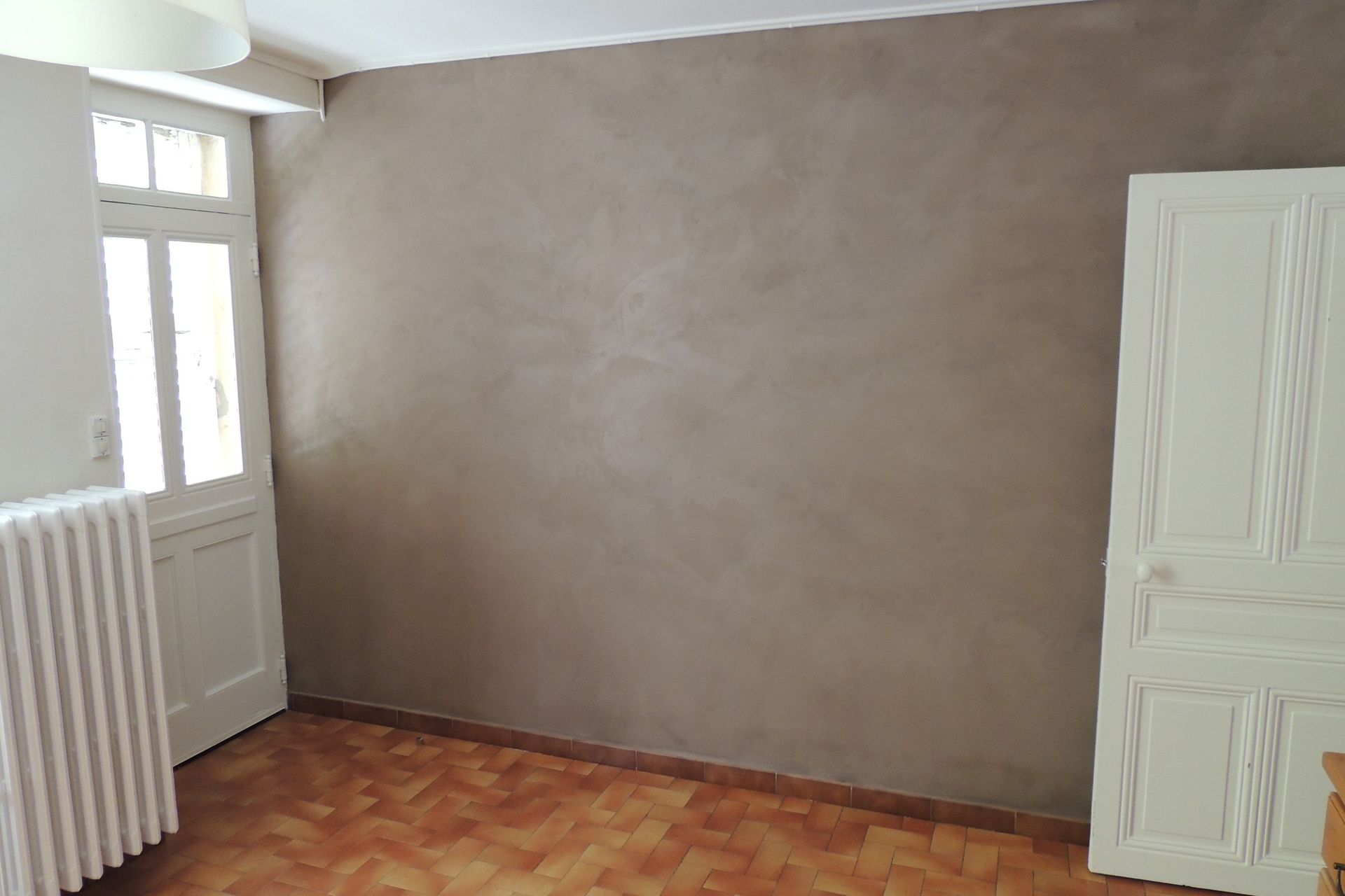 Application d'un enduit décoratif mural gris