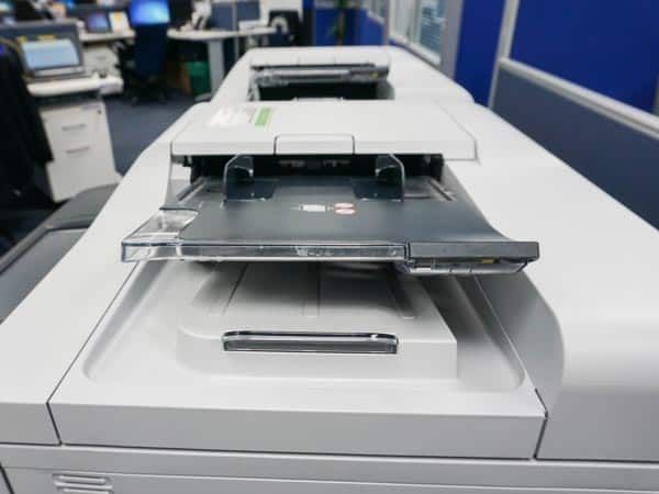 Una impresora está encima de una mesa en una oficina.