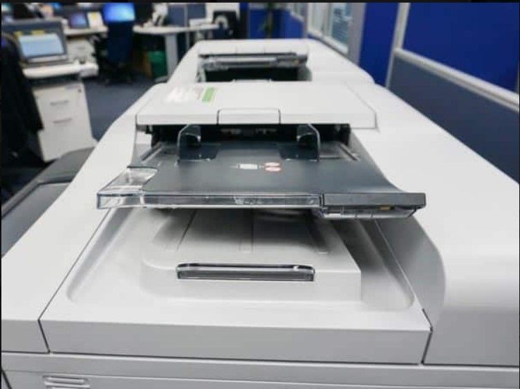 Una impresora está encima de una mesa en una oficina.