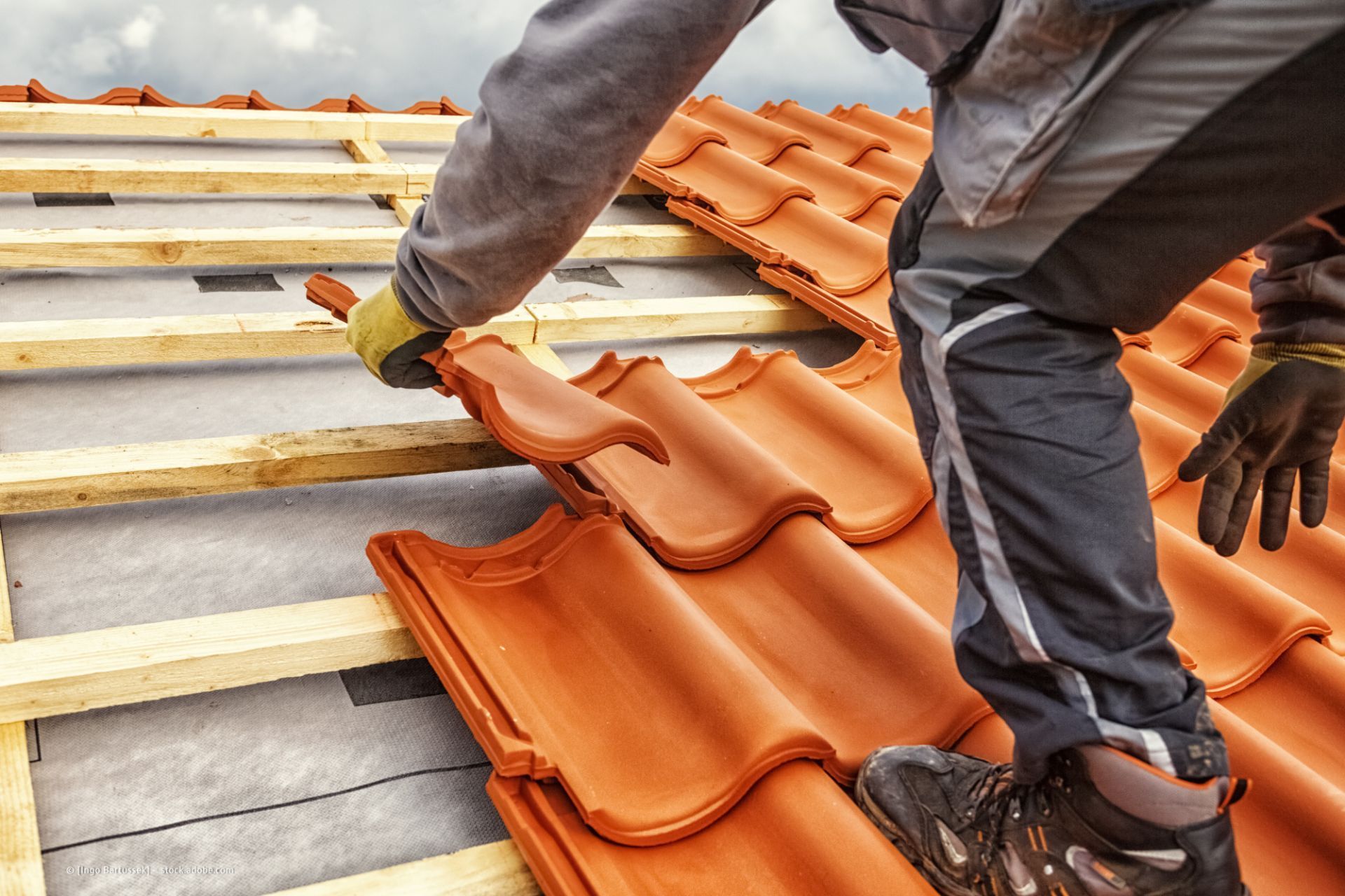 Dachdecker verlegt Dachpfannen