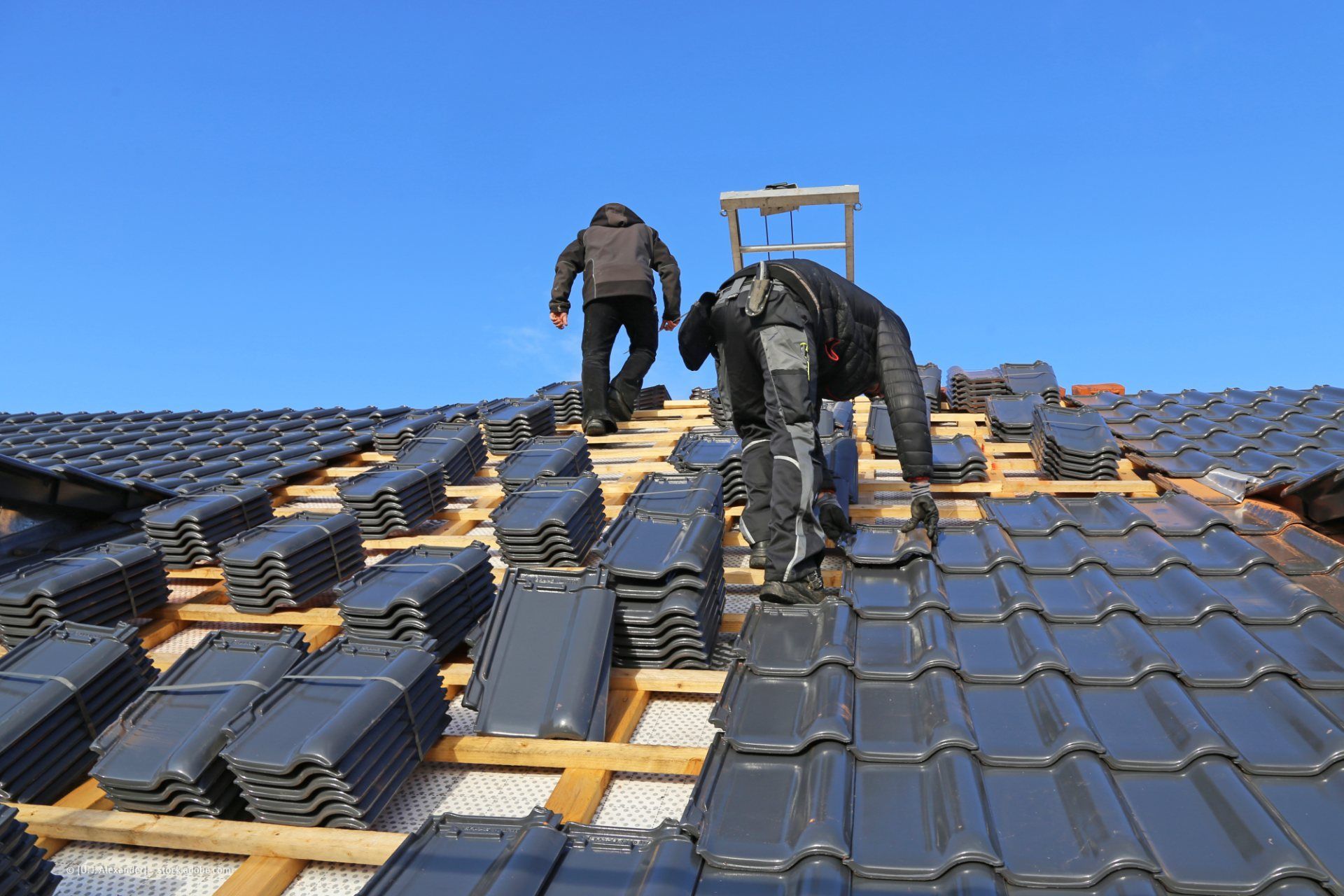 Dachdecker verteilen Dachziegel