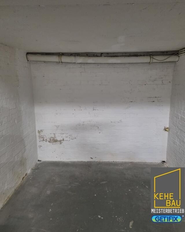 Ein leerer Raum mit einer weißen Wand und einem Betonboden.