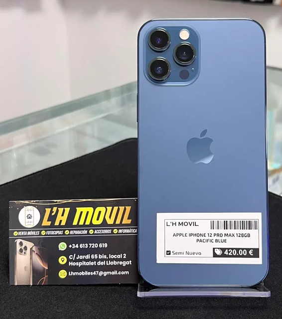 Se vende un iPhone 12 Pro azul, con un precio de 420 €, expuesto sobre una superficie negra junto al cartel de una tienda.