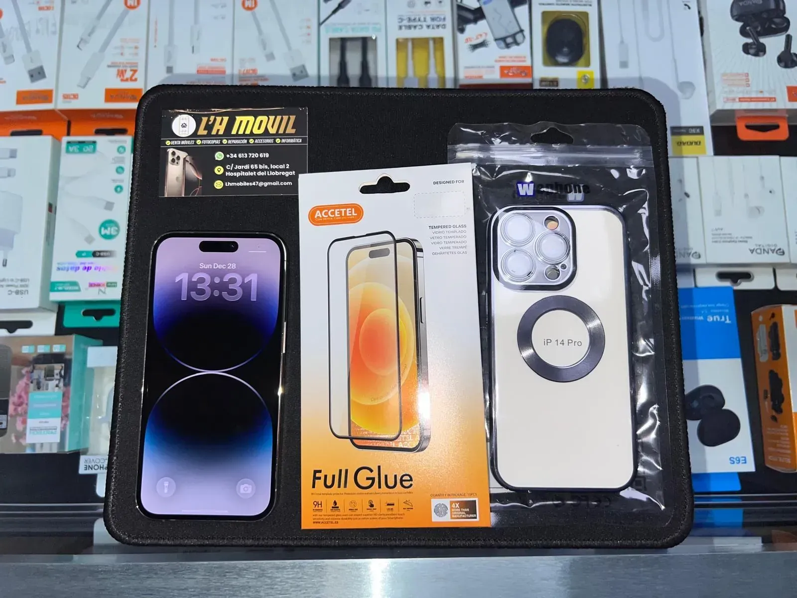 Teléfono y accesorios en exhibición: teléfono, protector de pantalla, funda para teléfono con anillo magnético.