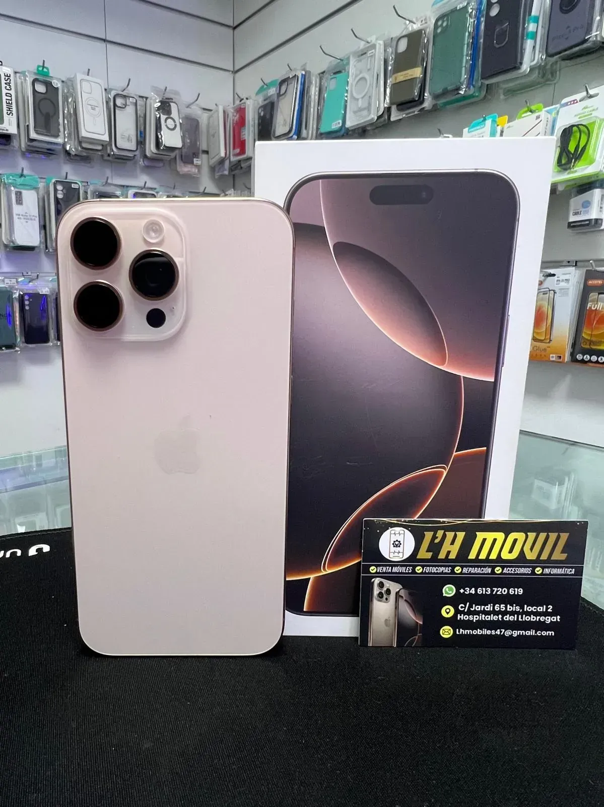 IPhone Pro rosa junto a su caja con un cartel de tienda.