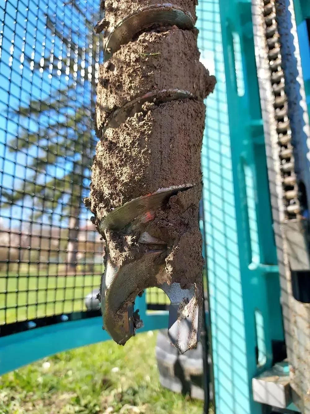 Foret recouvert de terre, partie d'une foreuse sarcelle, à l'extérieur.