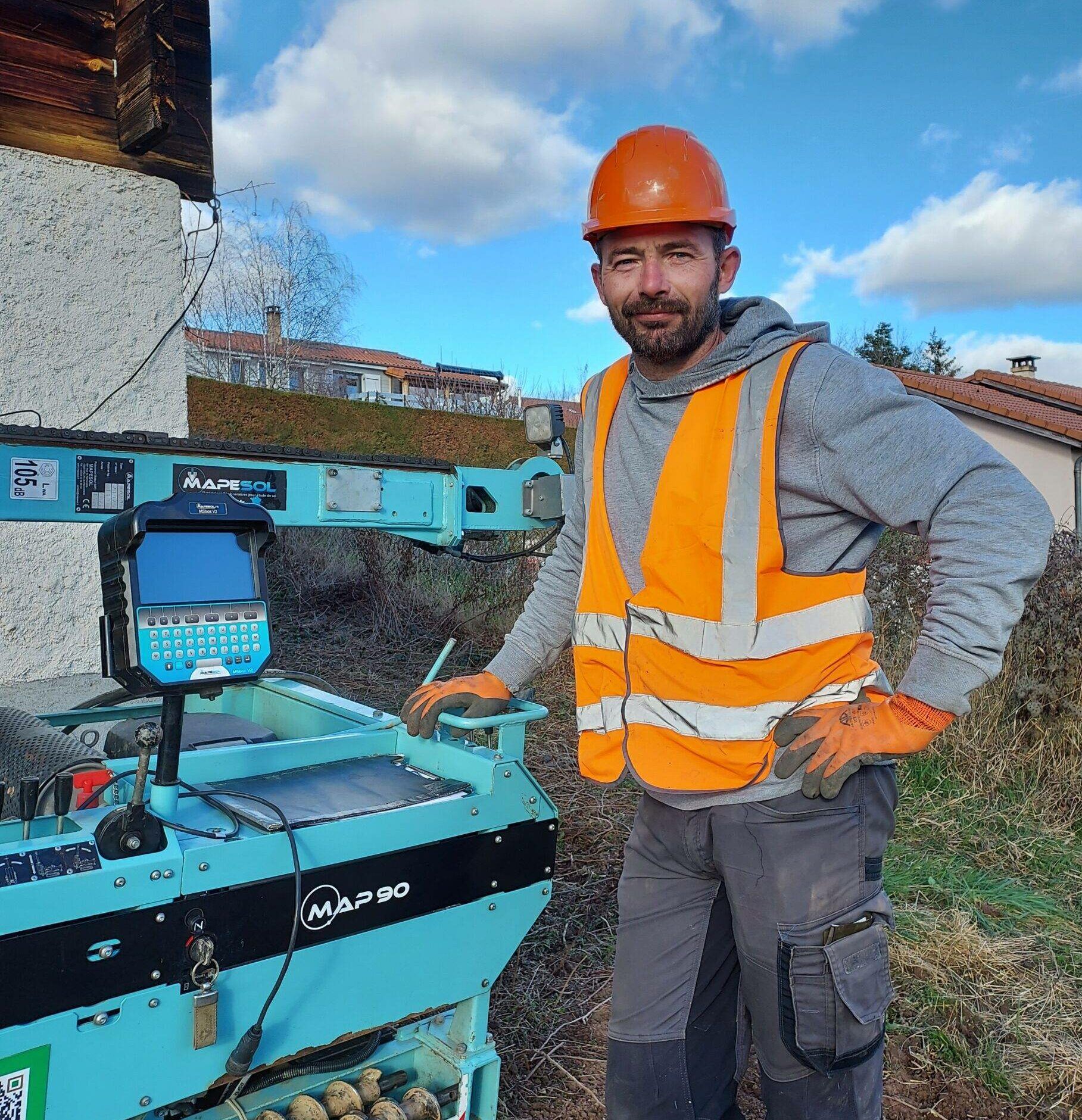 François Biechel débout à côté d'une machine.