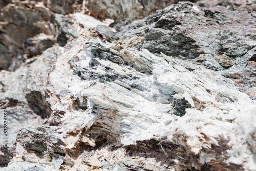 Gros plan d'une formation rocheuse. Texture stratifiée grise et blanche, possiblement des gisements minéraux.