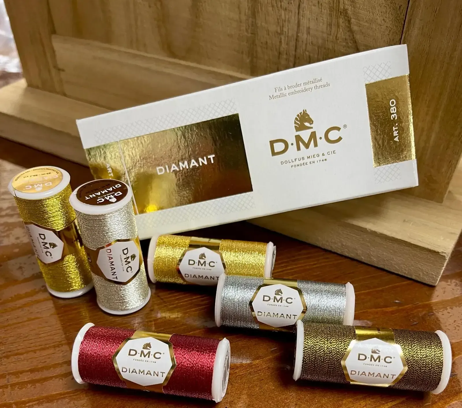 Un perchero metálico que exhibe varios bodys de bebé en fundas protectoras de plástico transparente.