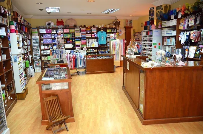 Una tienda de telas o manualidades bien iluminada, con mostradores de madera