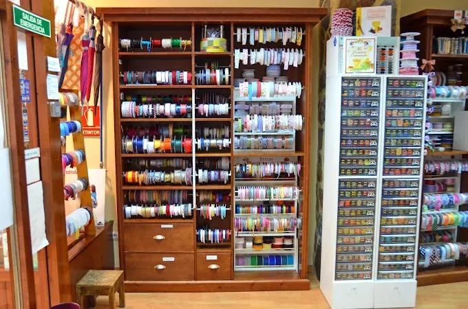 En la pared de una tienda de manualidades se exhiben estantes llenos 