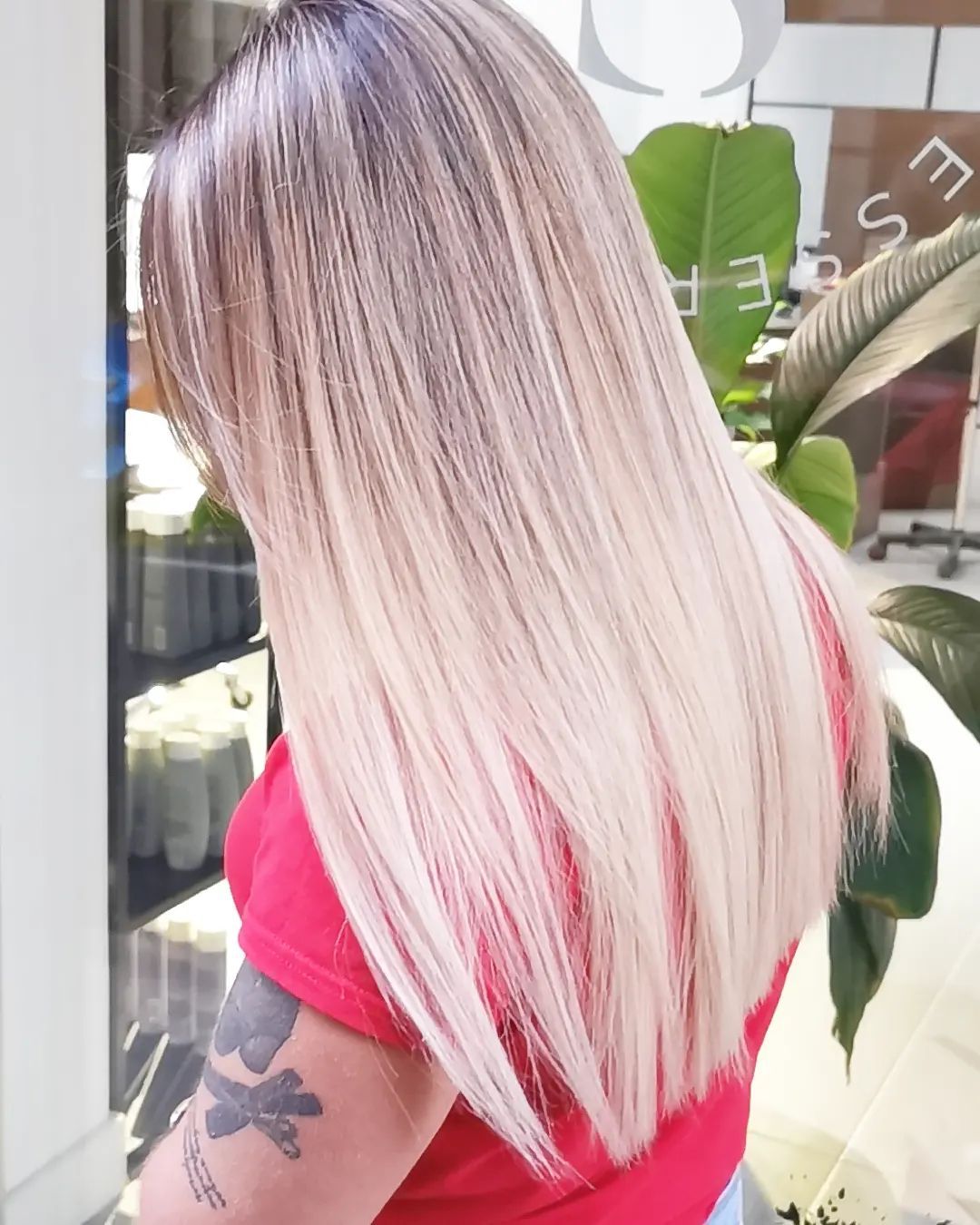 Una mujer con cabello largo y rubio y un tatuaje en el brazo.