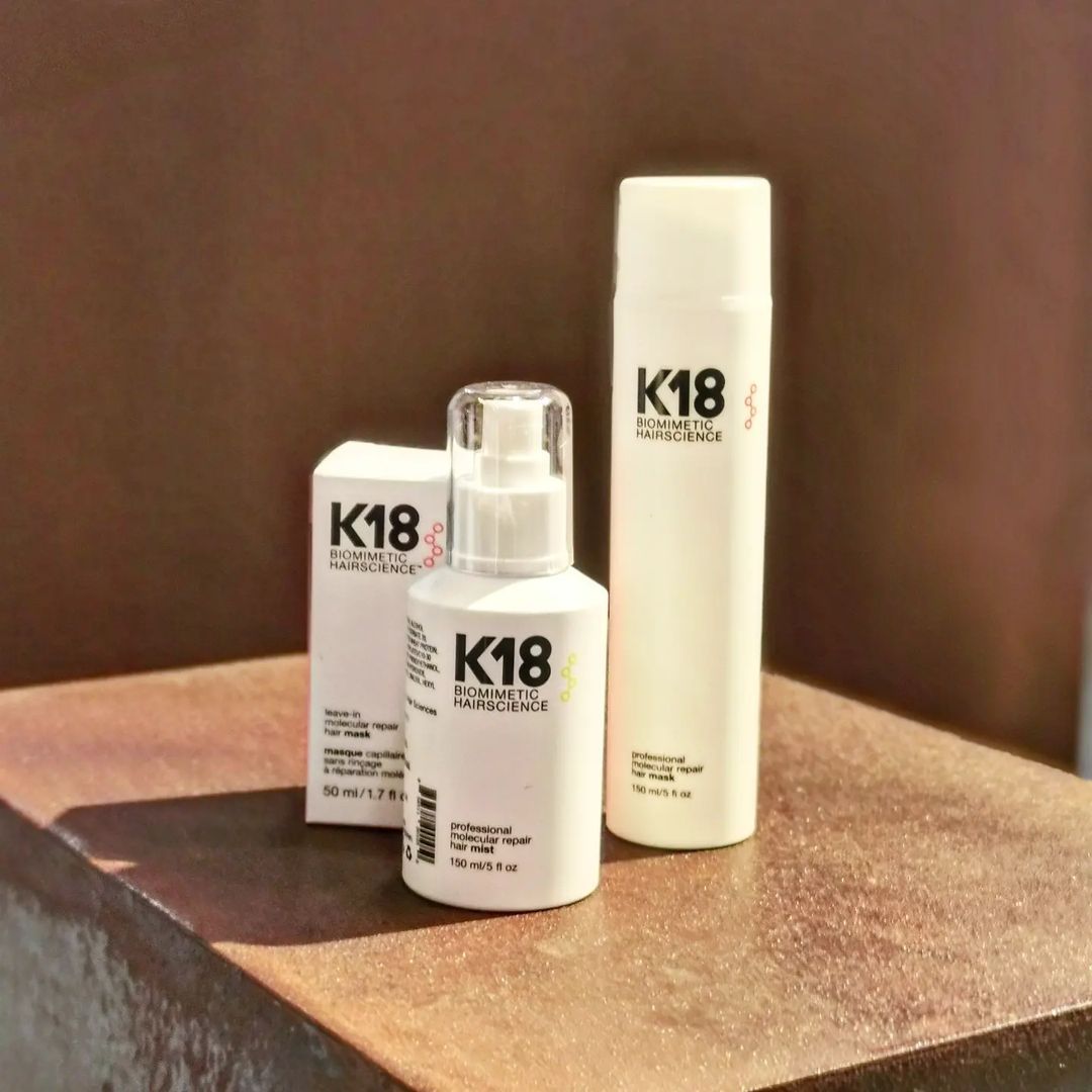 Hay tres botellas de K18 sobre una mesa.