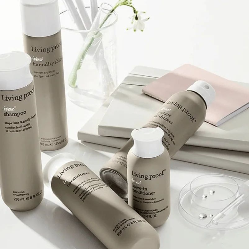 Varias botellas de productos Living Proof están sobre una mesa.