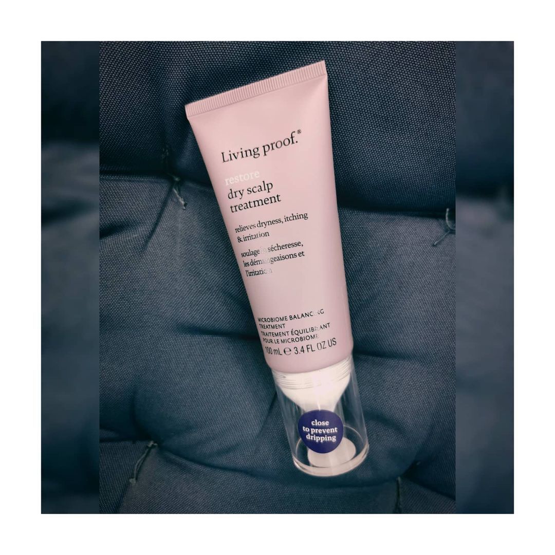 Un tubo de producto para el cabello se encuentra sobre un cojín.