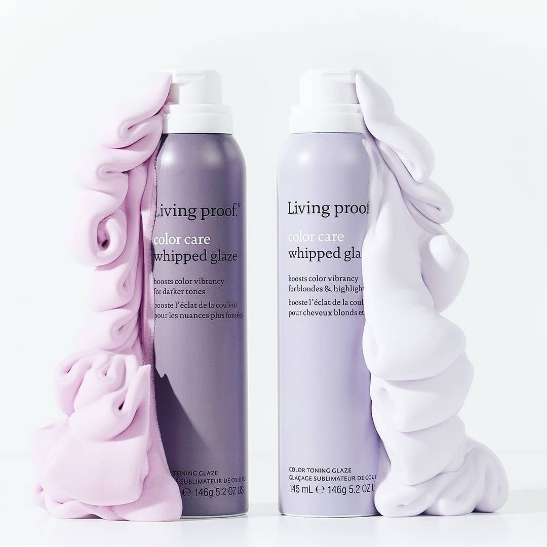 Dos botellas de productos para el cabello están una al lado de la otra sobre una mesa.