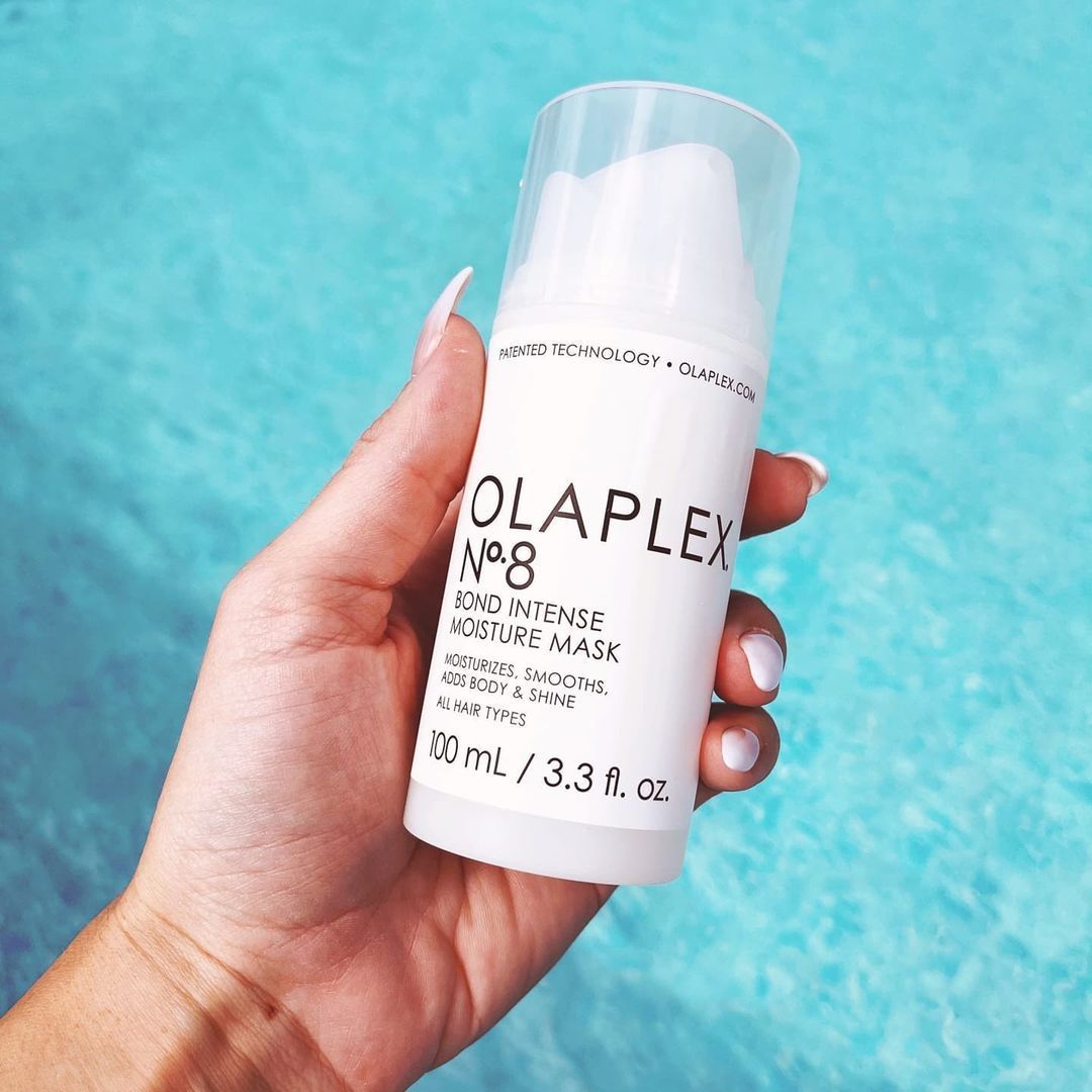 Una persona sostiene una botella de olaplex no 8