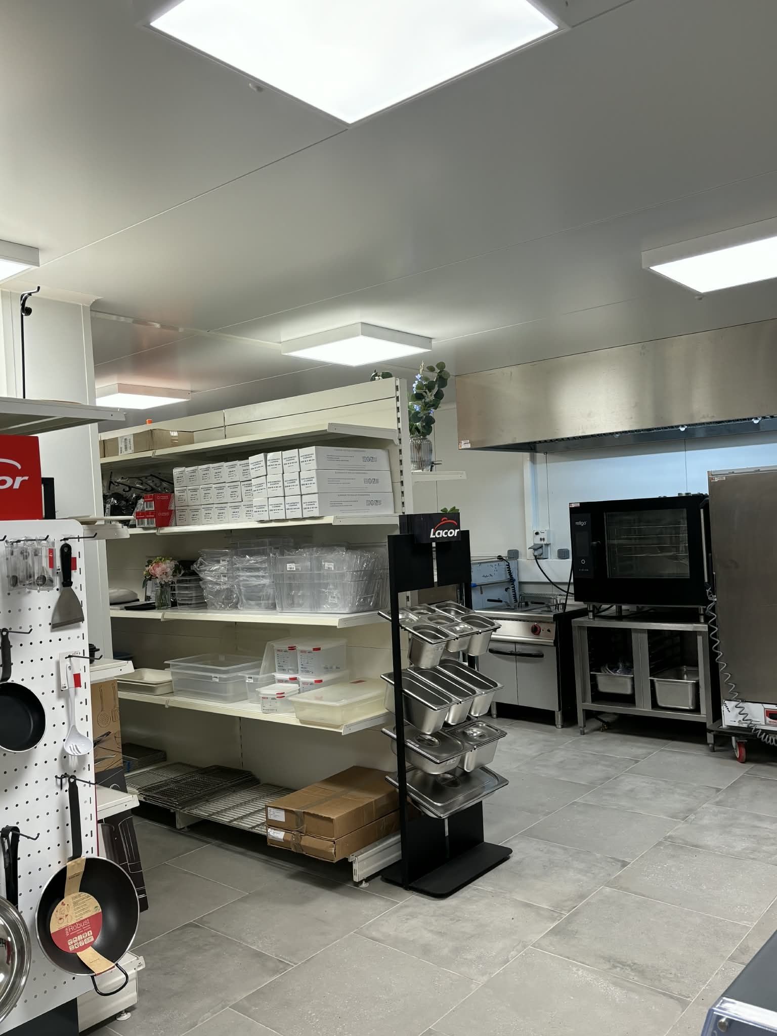 Intérieur d'un magasin d'articles de cuisine avec des étagères présentant des produits et du matériel de cuisine.