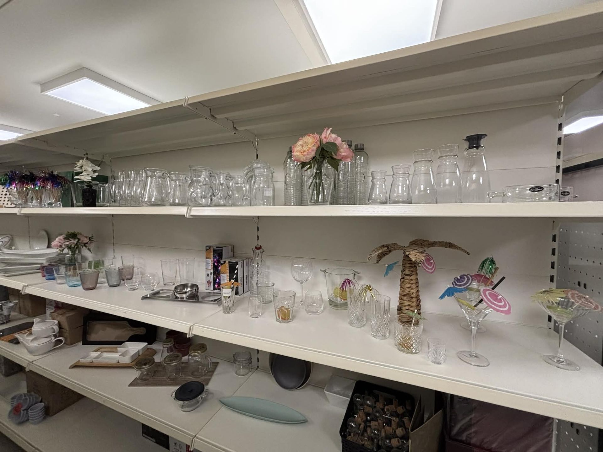 Des étagères remplies de verrerie, de vases et d'objets décoratifs dans un magasin.