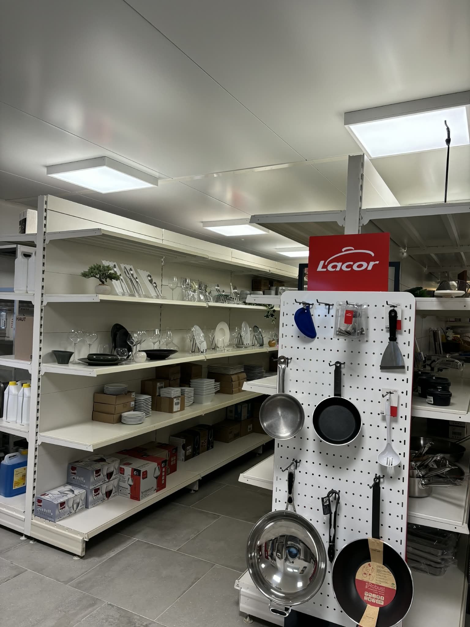 L'intérieur d'un magasin avec des étagères présentant des articles et ustensiles de cuisine.