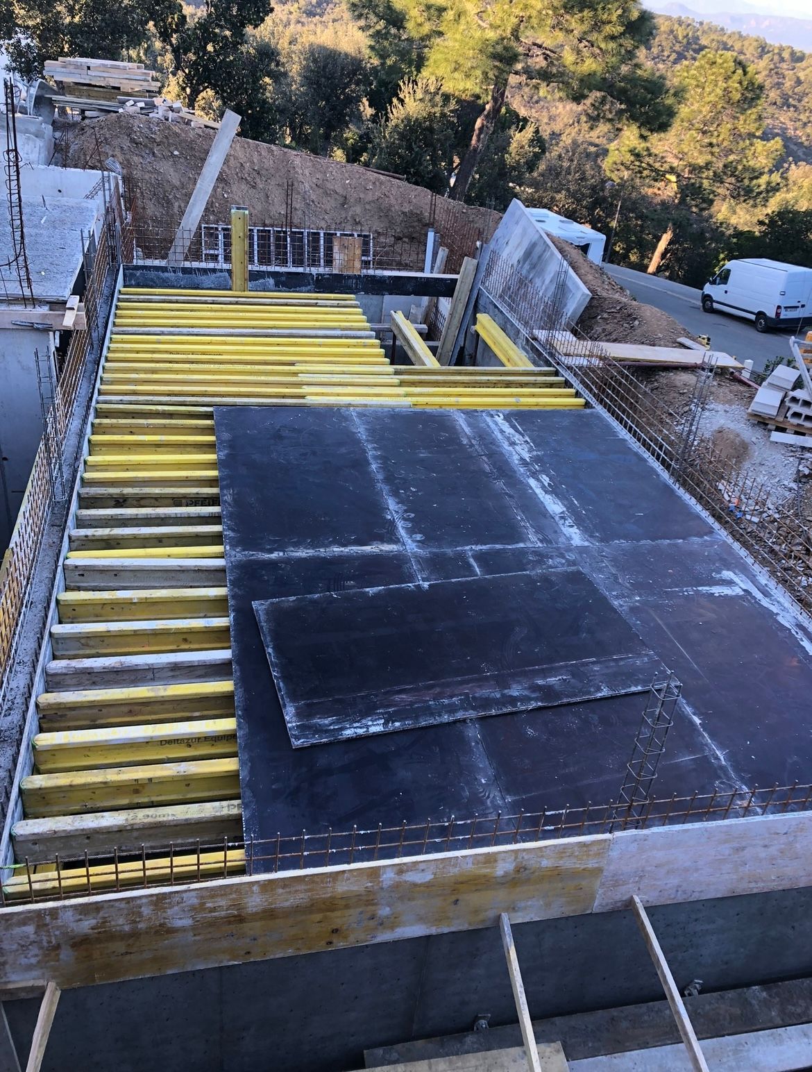 Béton frais coulé dans des coffrages de fondations en bois sur un chantier de construction.