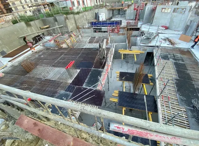 Chantier de construction avec dalles d'armature et puits ouverts dans une structure de bâtiment en béton armé