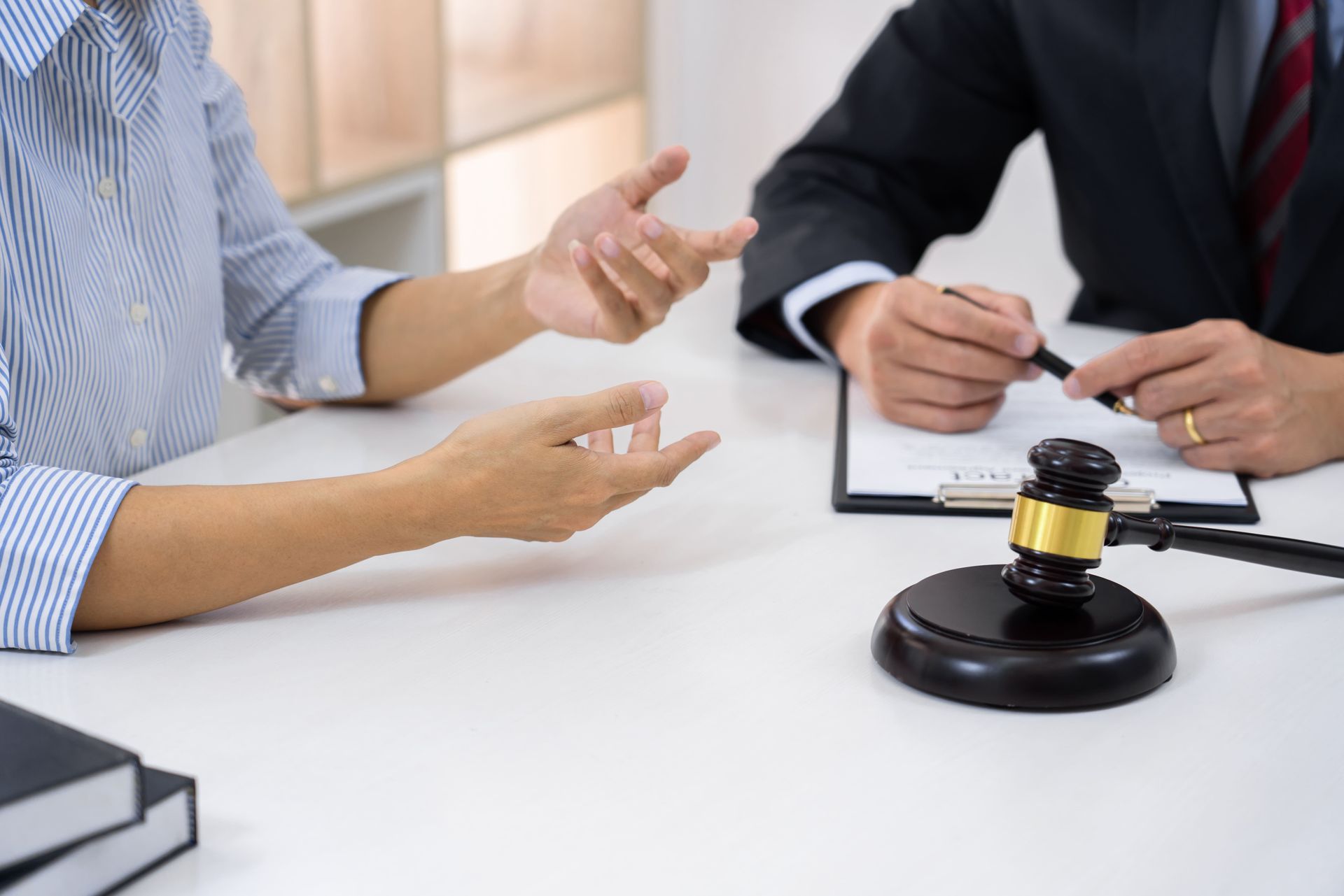 Un hombre y una mujer están sentados en una mesa con un mazo de juez.