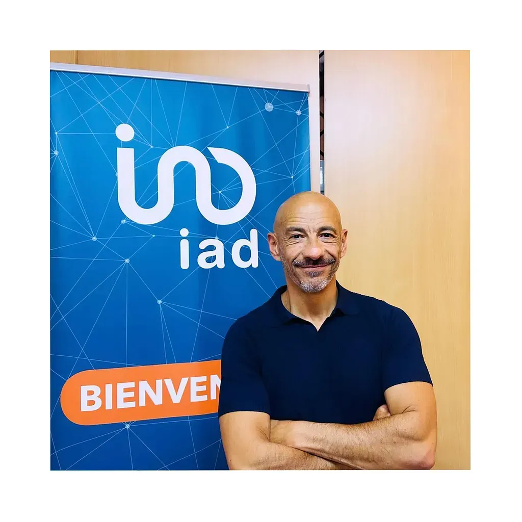 Un hombre está parado frente a un cartel que dice iad