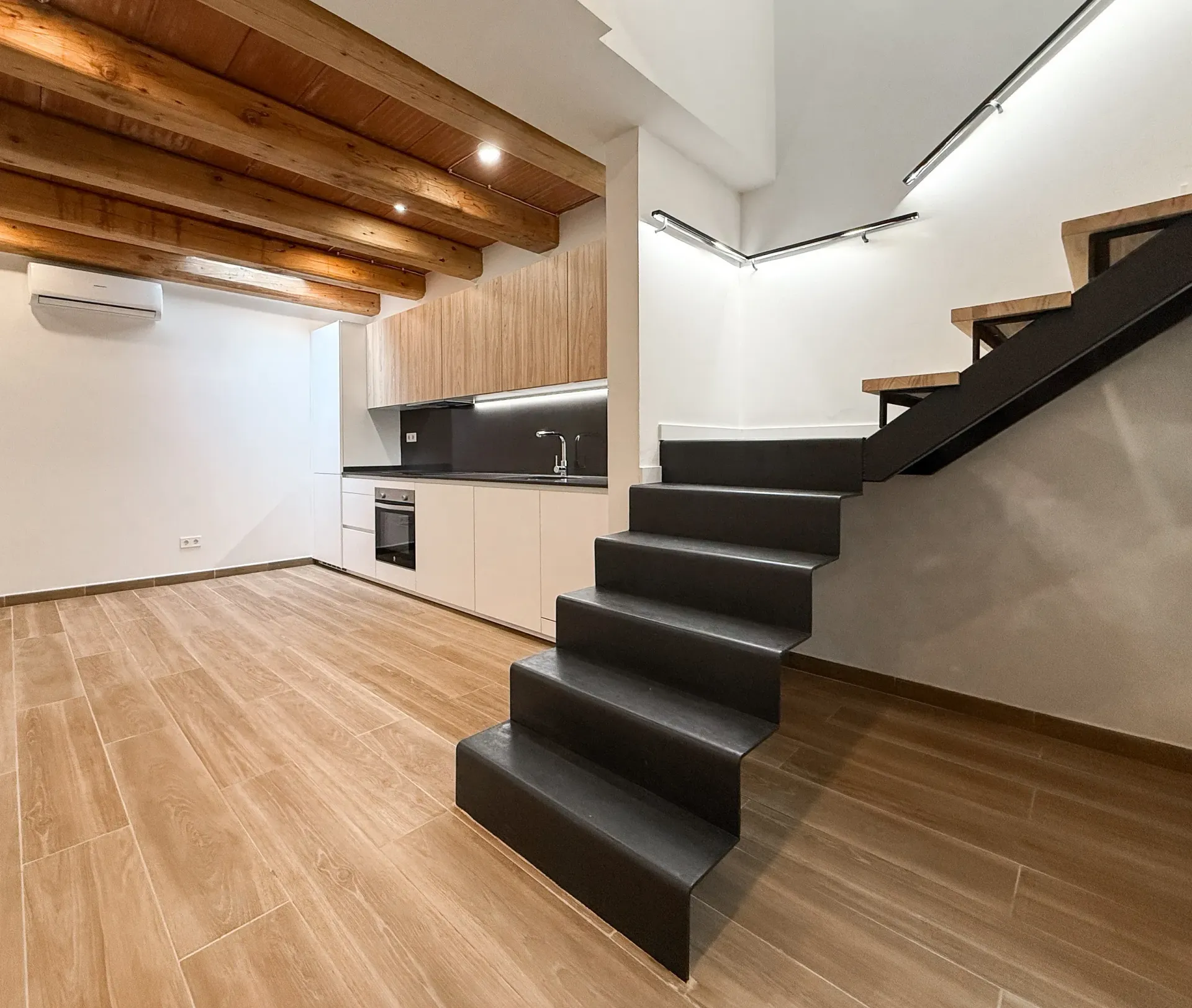 Una cocina con una escalera que conduce al segundo piso.