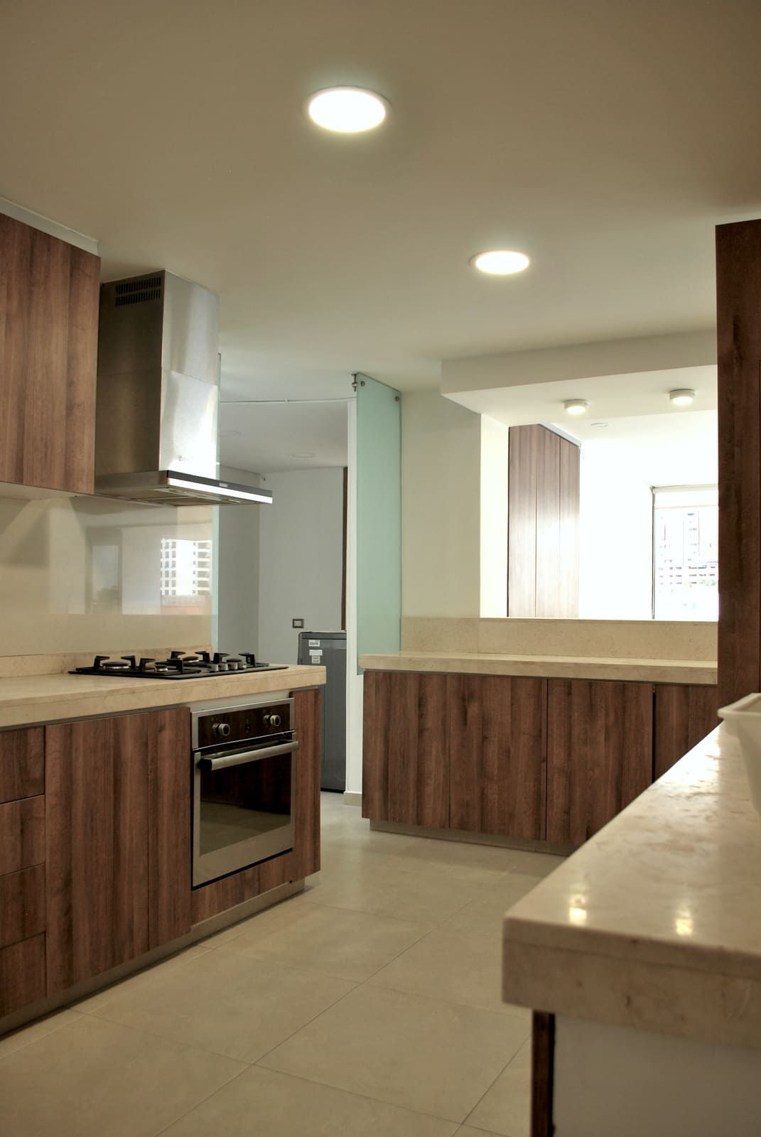 Una cocina con gabinetes de madera y electrodomésticos de acero inoxidable.