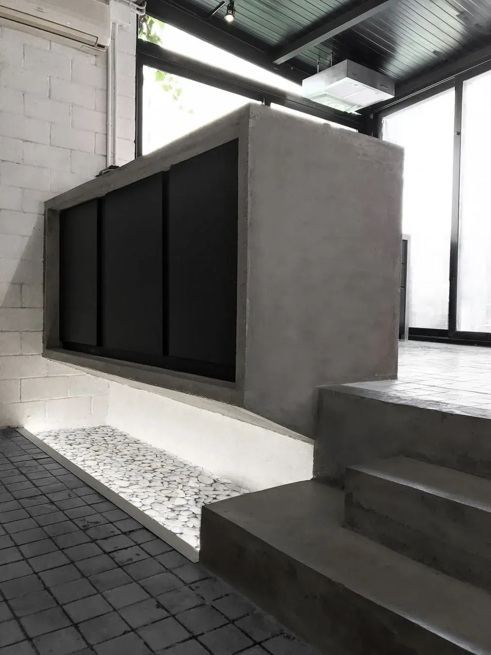 Una escalera que conduce a un mostrador de hormigón en una habitación.