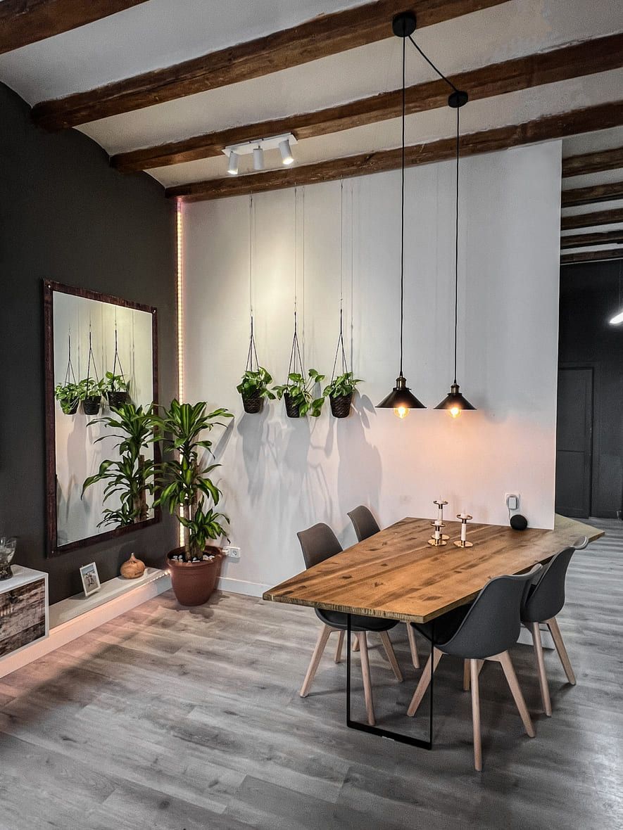 Un comedor con mesa y sillas de madera.