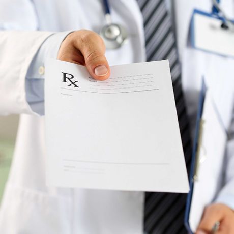 Doctor sosteniendo una receta para un paciente.