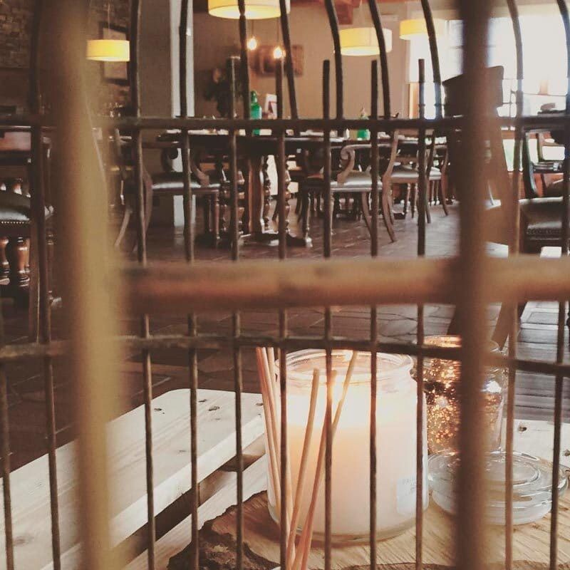 Una jaula de pájaros con una vela dentro.