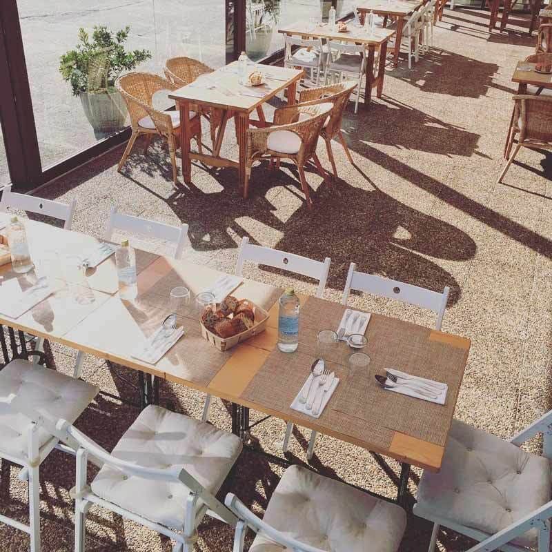 Un restaurante con mesas y sillas preparadas para una comida.