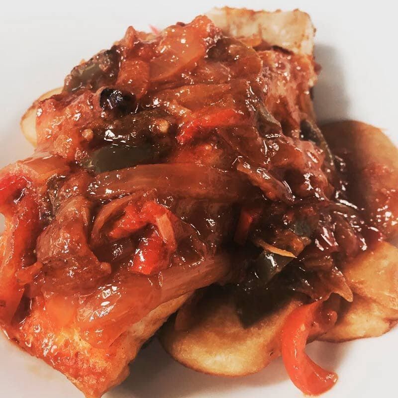 Un primer plano de un plato de comida con salsa encima.