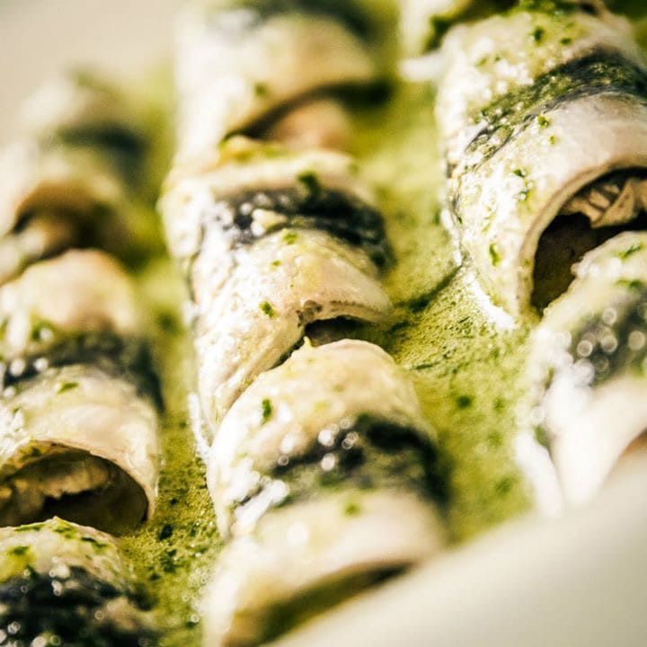 Un primer plano de un plato de comida con una salsa verde encima.