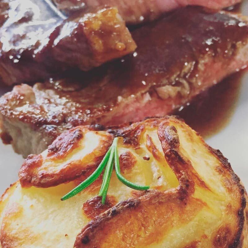 Un primer plano de un plato de comida con patatas y carne.