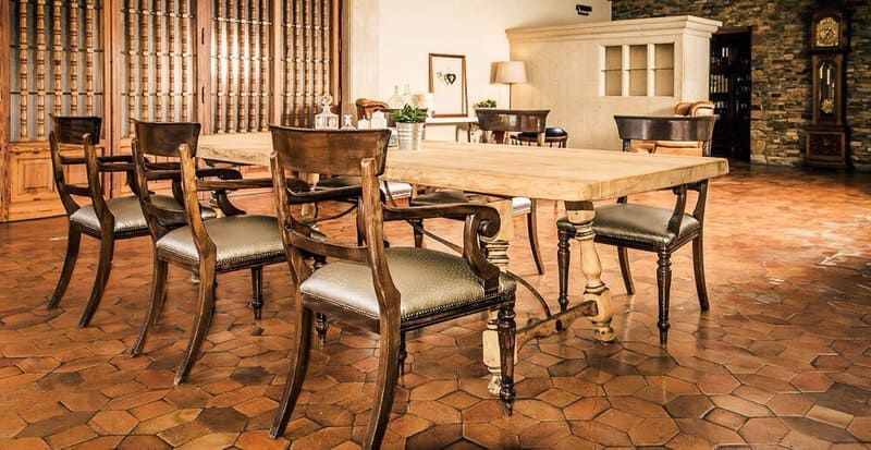 Un comedor con una mesa y sillas sobre un suelo de baldosas.