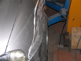 Eine Nahaufnahme eines Autos mit einem beschädigten Kotflügel