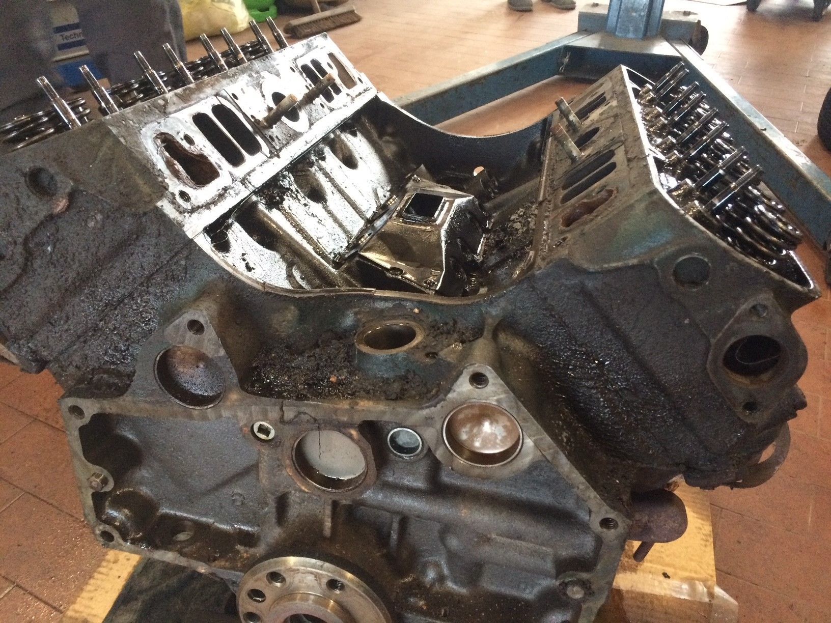 Auf einem Holztisch steht ein schwarzer Motorblock.