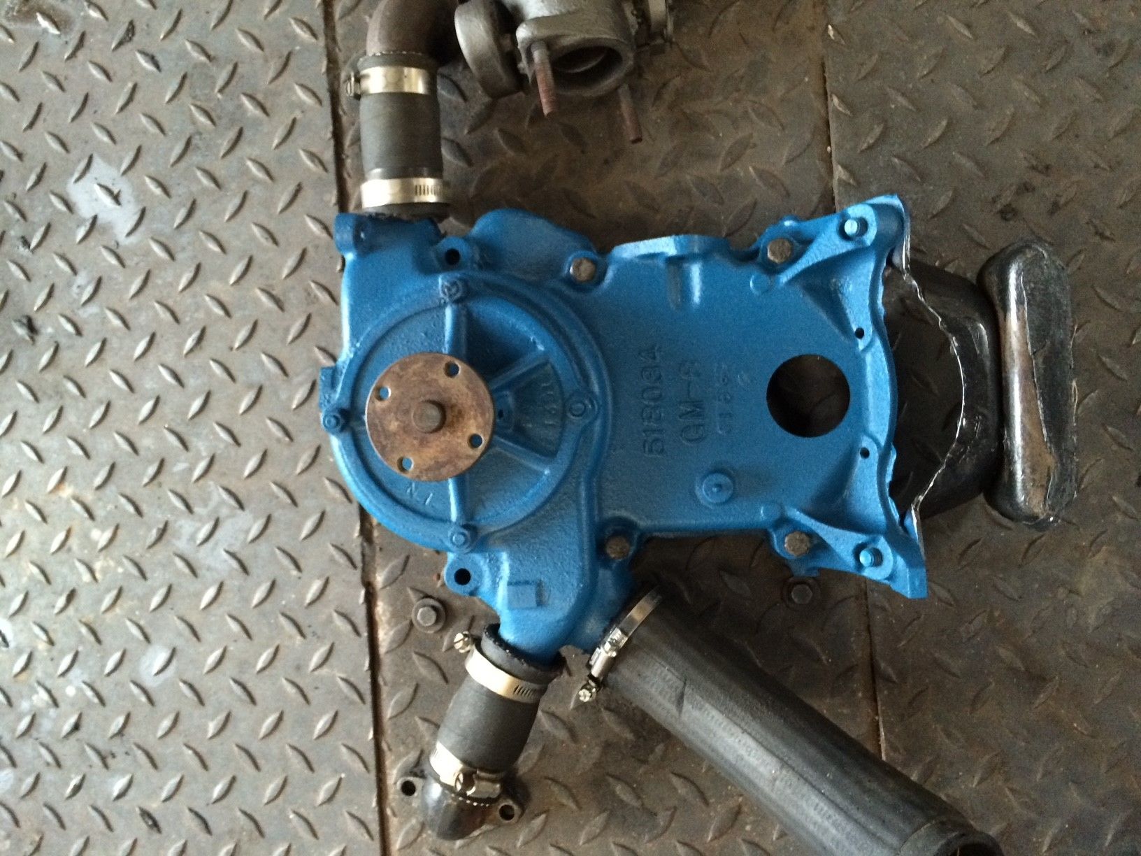 Eine blaue Wasserpumpe steht auf einer Metalloberfläche