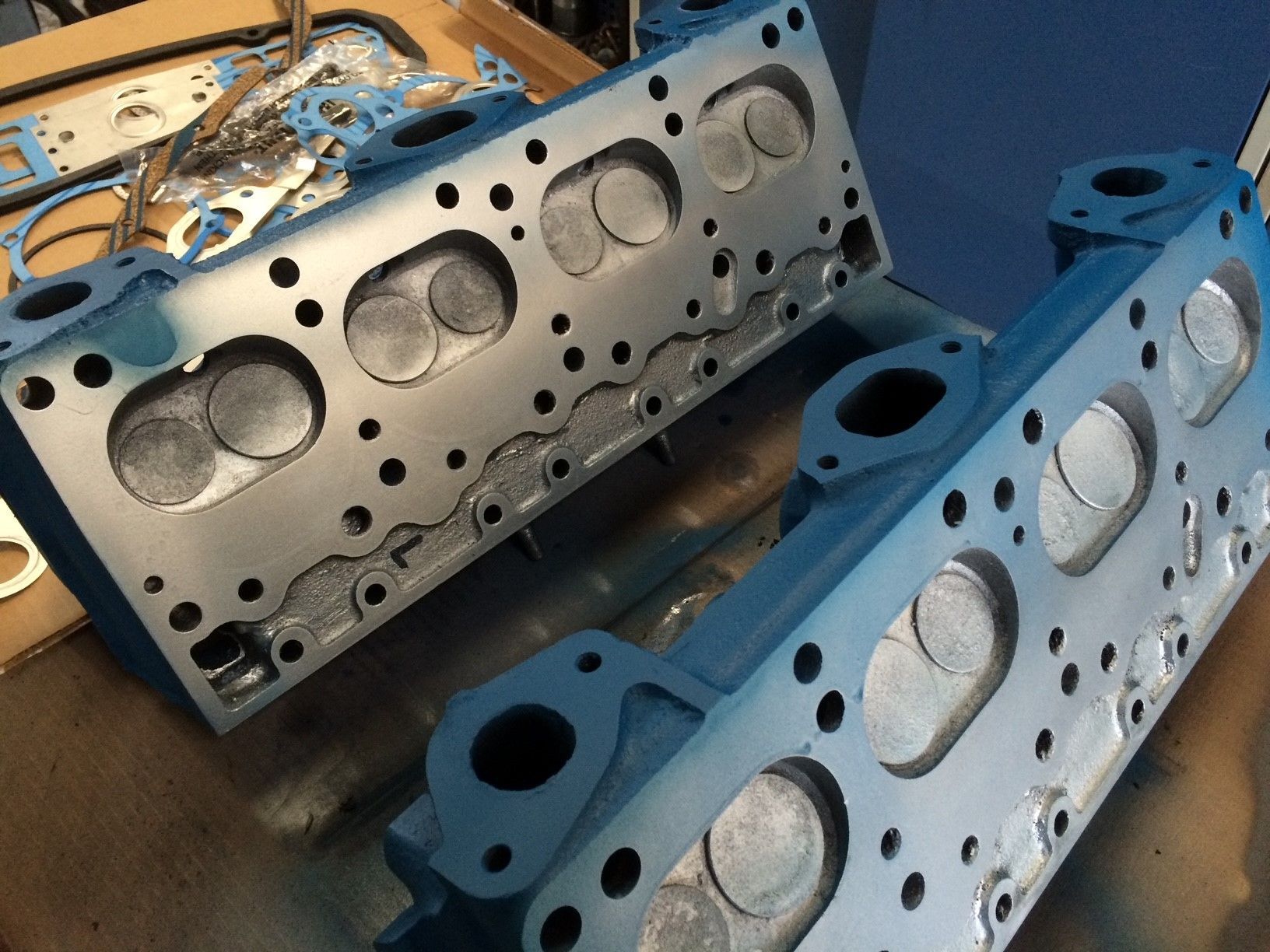 Zwei Zylinderköpfe liegen übereinander auf einem Tisch.