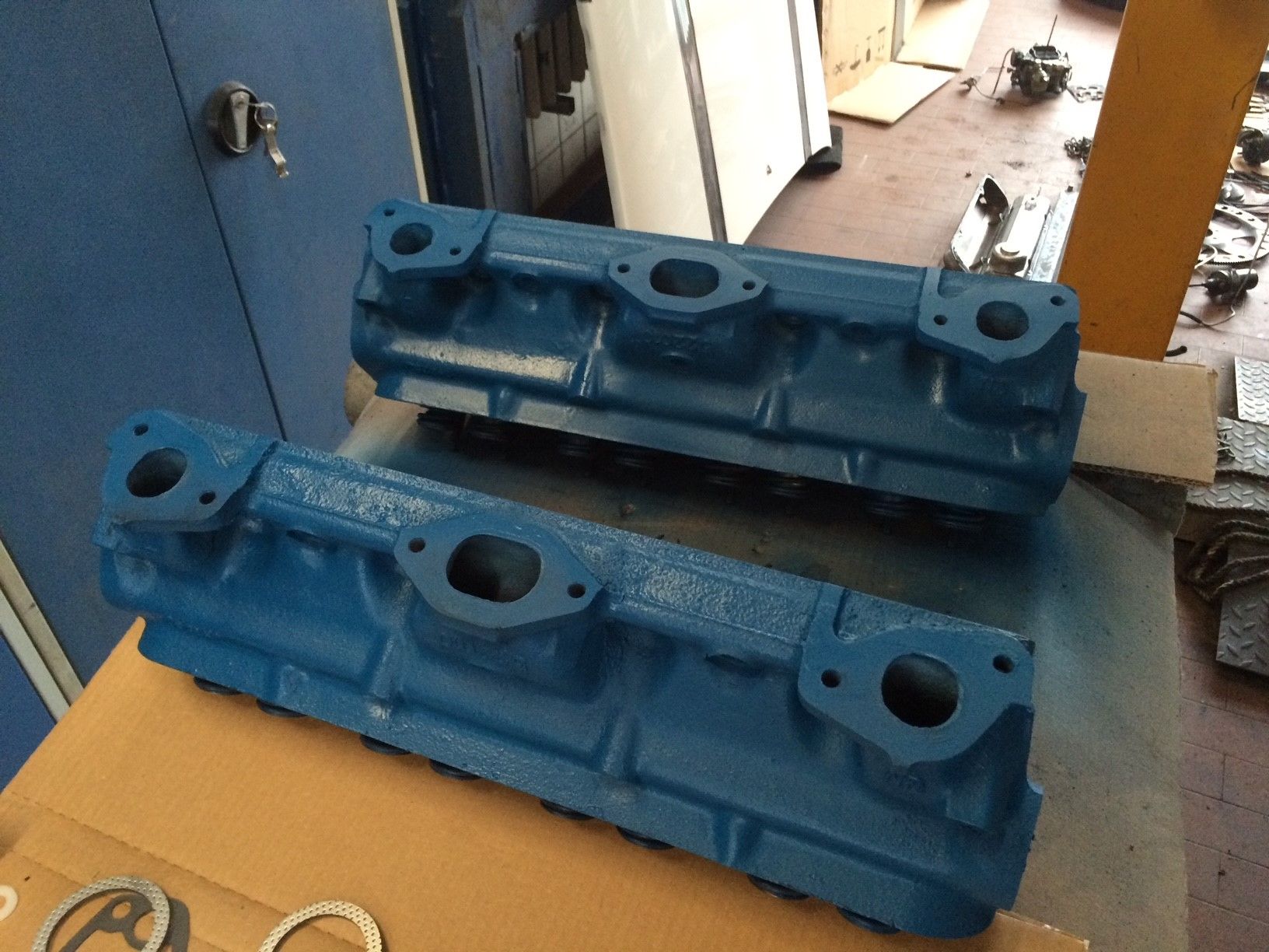 Zwei blaue Motorköpfe sitzen auf einem Karton