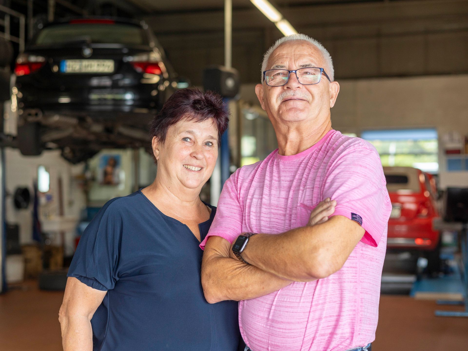 Ein Mann und eine Frau posieren in einer Garage für ein Foto.