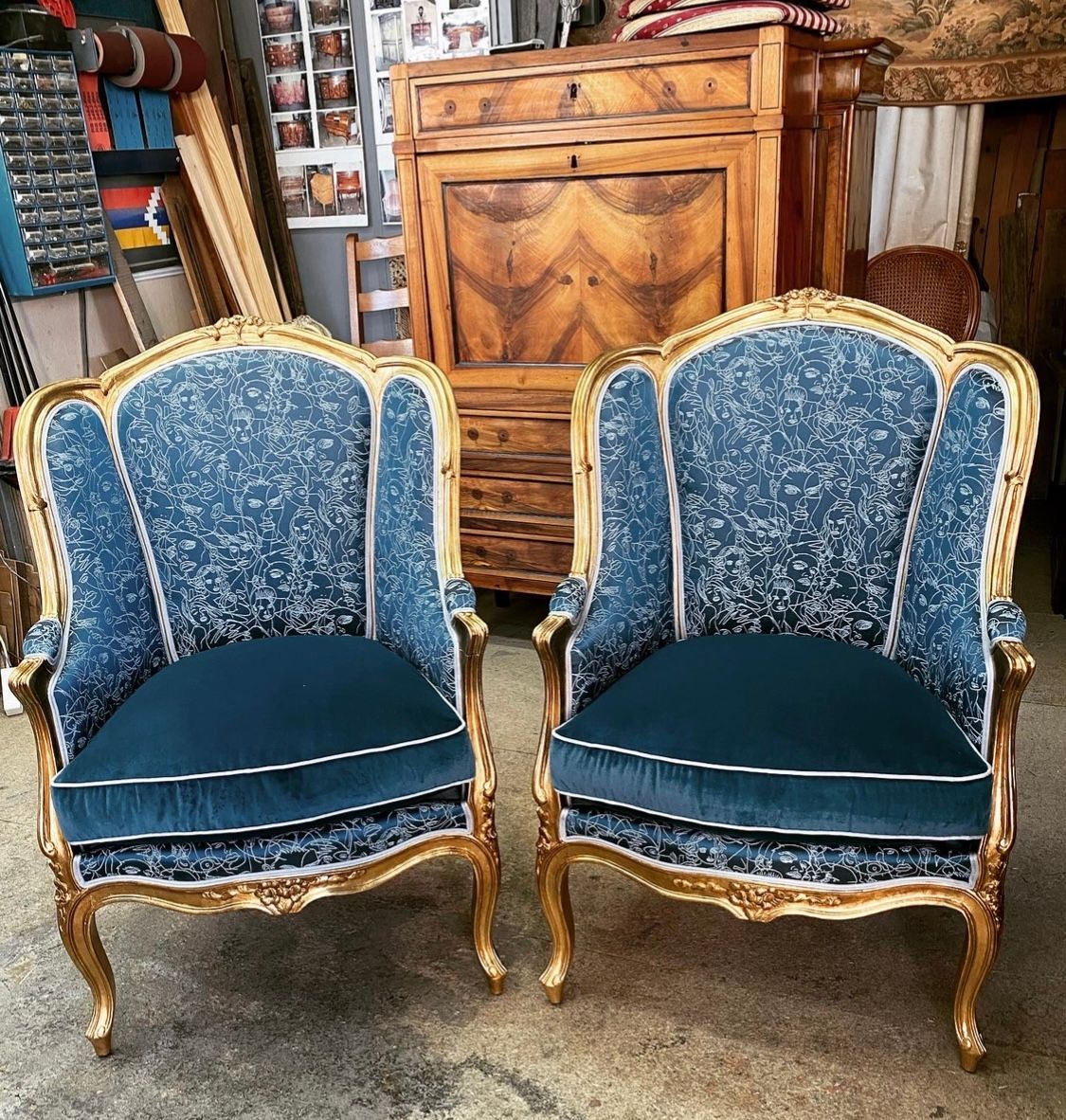 Deux fauteuils tapissés en bleu avec des dorures sur le bois