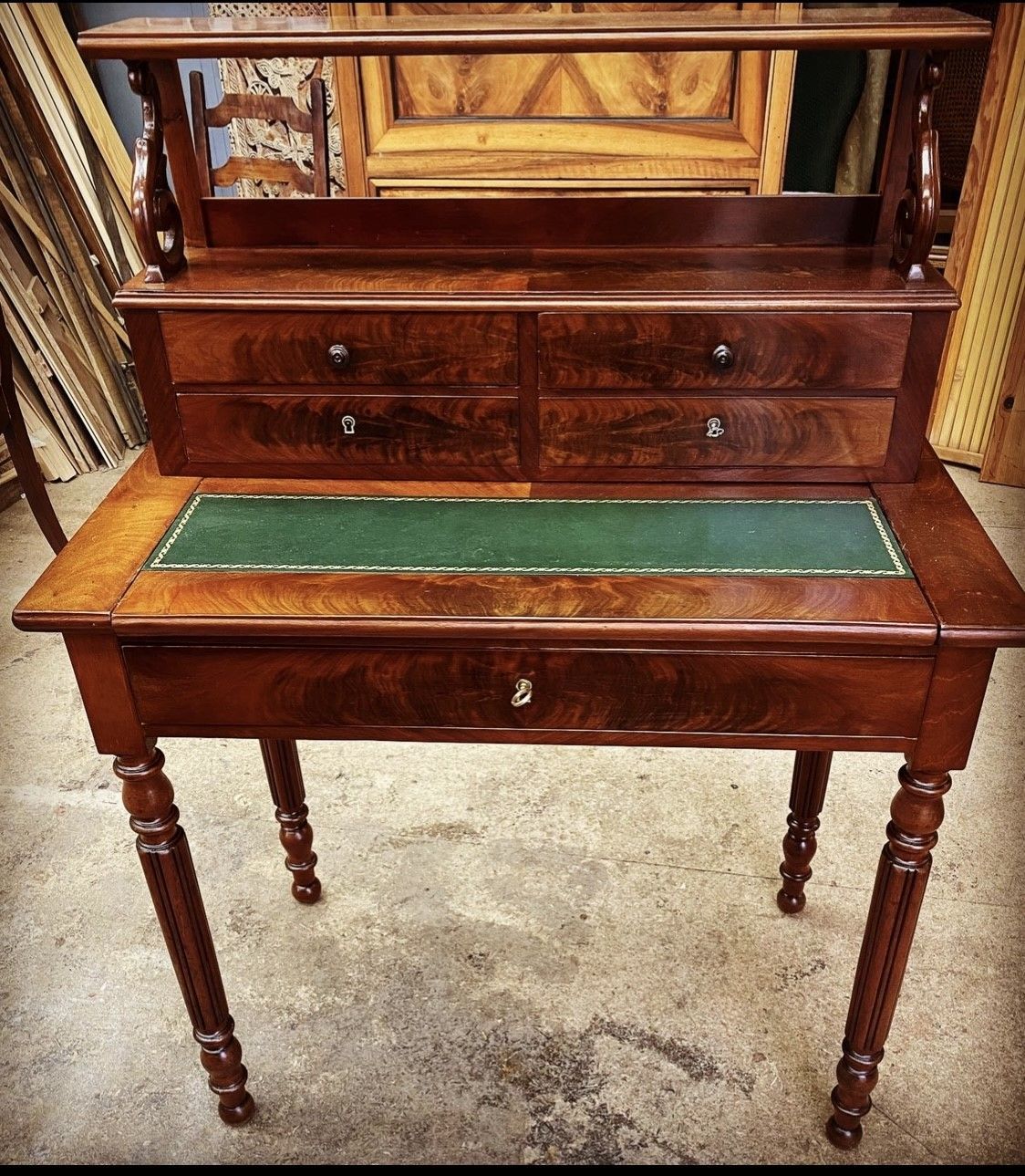 Console tapissée de cuir vert au bois verni vue de face