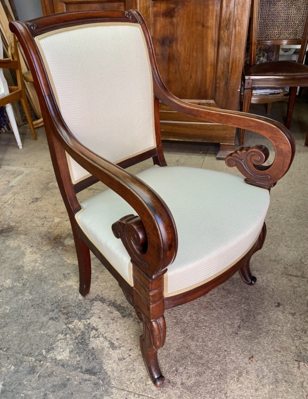 Fauteil ancien en bois sombre tapissé de textile ou de cuir blanc 