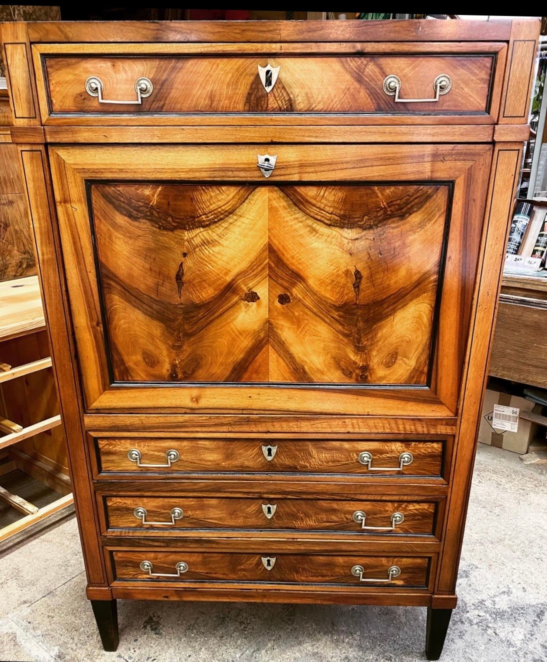 Armoire de bois clair et foncé vernie aux ferrures dorées
