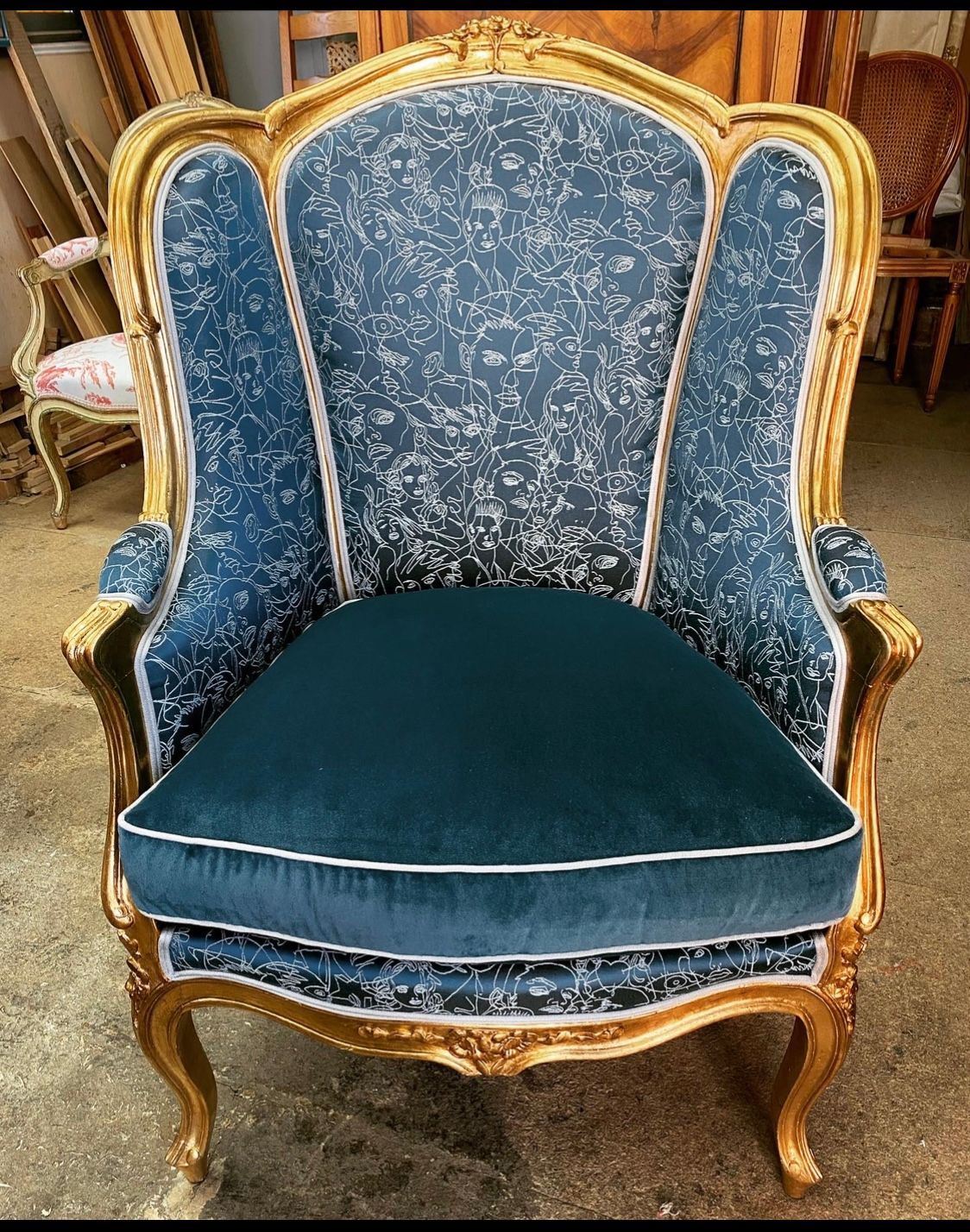Fauteuil ancien tapissé de bleu avec des motifs blancs 